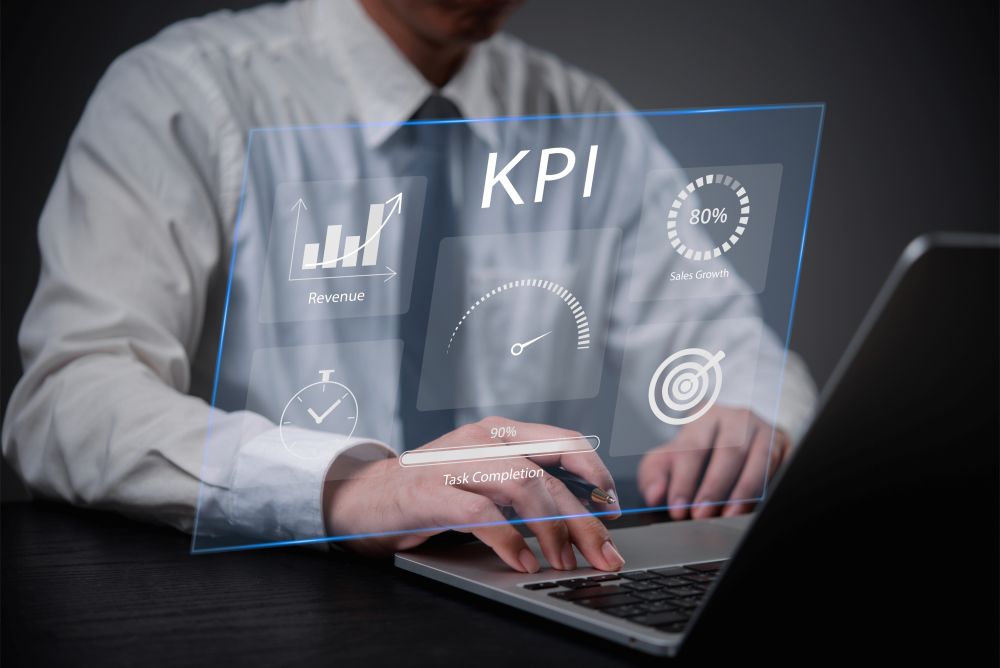 A person in a suit uses a laptop with a transparent digital interface displaying yard management KPIs, including revenue, sales growth, task completion, and target icons. C3 Solutions